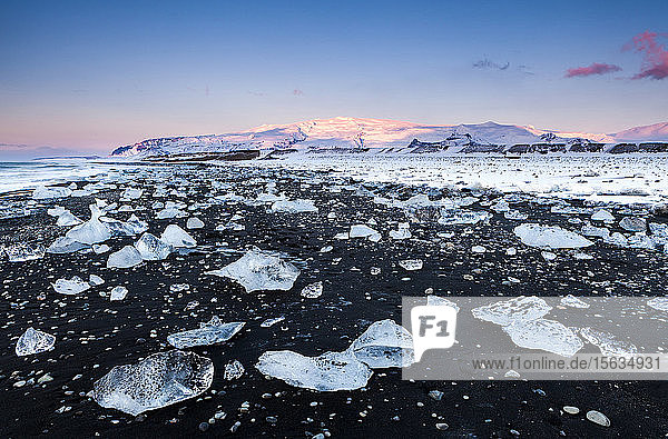 Ansicht von Eisbergen am schwarzen Strand gegen den Himmel bei Sonnenuntergang  Jokulsarlon  Island