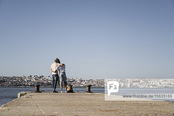 Young couple standing on pier at the waterfront  Lisbon  Portugal