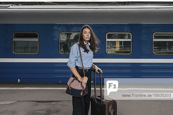 Junge weibliche Reisende wartet am Bahnhof