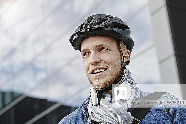 Porträt eines Studenten mit Fahrradhelm und Kopfhörer
