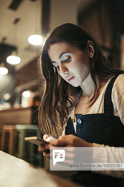 Frau benutzt ihr Smartphone in einem Café