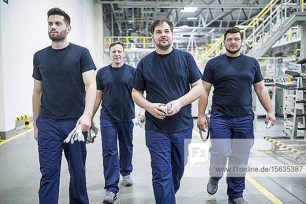 Kollegen machen eine Pause und gehen in einer modernen Fabrik spazieren