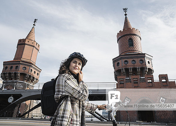 Frau mit einem Fahrrad in der Stadt an der Oberbaumbrücke  Berlin  Deutschland