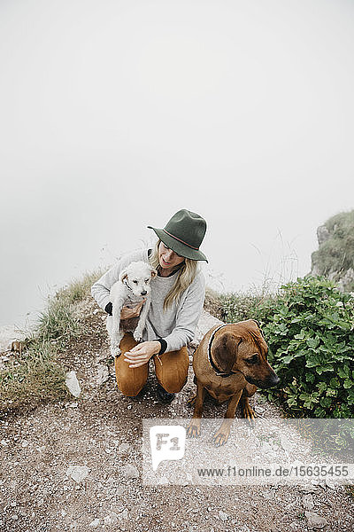 Junge Frau mit zwei Hunden auf dem Aussichtspunkt