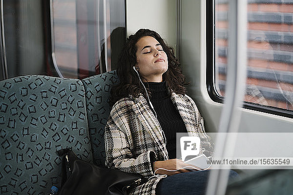 Young woman with closed eyes relaxing on a subway