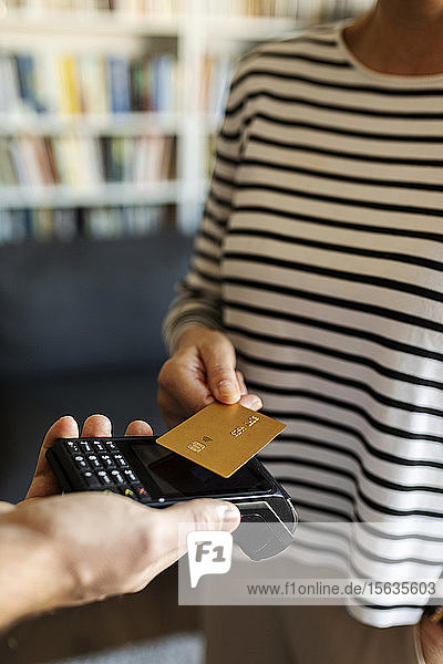 Nahaufnahme einer Frau  die zu Hause mit Kreditkarte bezahlt