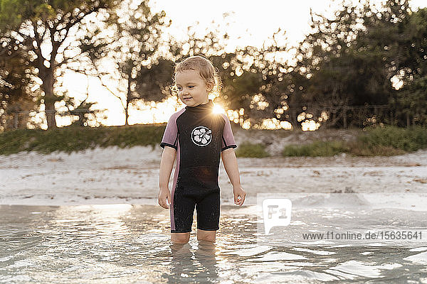 Cute toddler girl standing in the sea