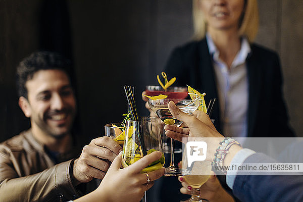 Kollegen stoßen in einer Bar mit Cocktails an