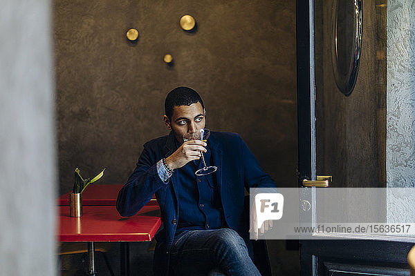 Junger Mann entspannt sich bei einem After-Work-Cocktail