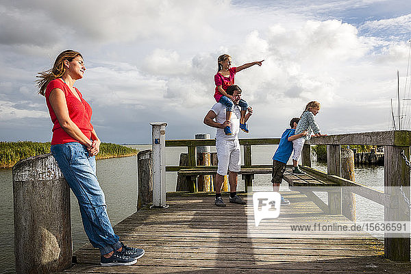 Familie steht auf einem Steg und schaut auf die Aussicht  Ahrenshoop  Mecklenburg-Vorpommern  Deutschland