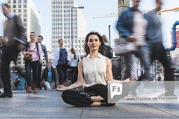 Junge Geschäftsfrau praktiziert Yoga in der Stadt zur Hauptverkehrszeit  Berlin  Deutschland