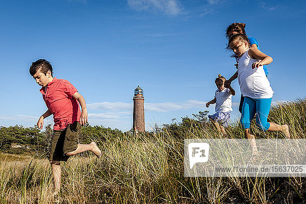 Family running in a beach dune  Darss  Mecklenburg-Western Pomerania  Germany