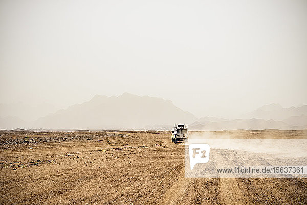 Geländewagen  der sich bei strahlendem Sonnenschein in trockener Landschaft vor klarem Himmel bewegt  Suez  Ägypten