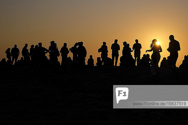 Portugal  Algarve  Silhouetten von Menschen  die sich am Kap Saint Vincent gegen die untergehende Sonne entspannen