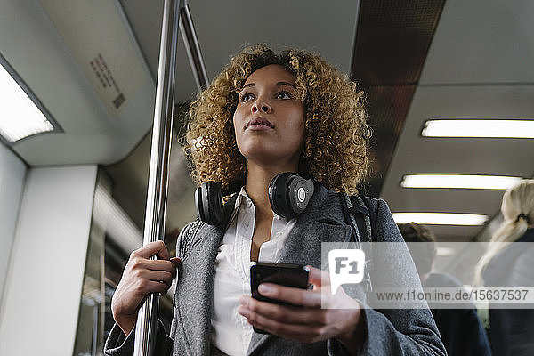 Frau mit Smartphone in der U-Bahn