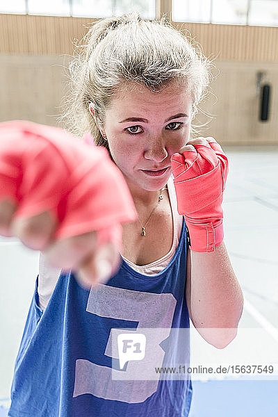 Portrait of confident female boxer in sports hall