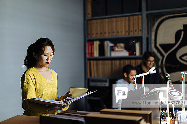 Young woman looking at files in office