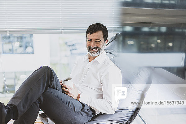 Portrait of smiling mature businessman having a coffee break