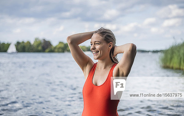Lächelnde Frau steht an einem See