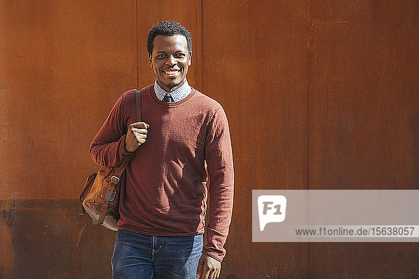 Portrait of a smiling young man  carrying bag