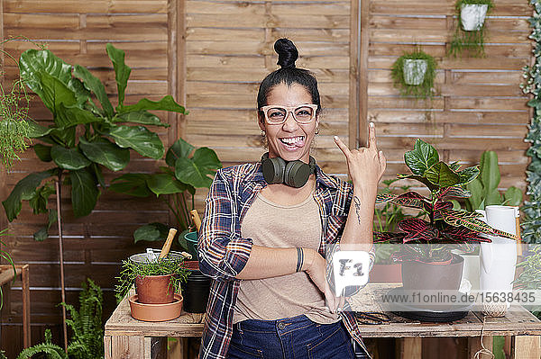 Porträt einer glücklichen jungen Frau  die auf ihrer Terrasse gärtnert
