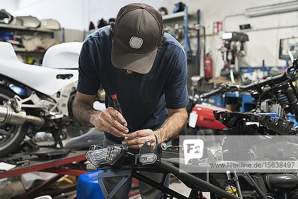 Mechanic in a repair garage repairing a motorcycle
