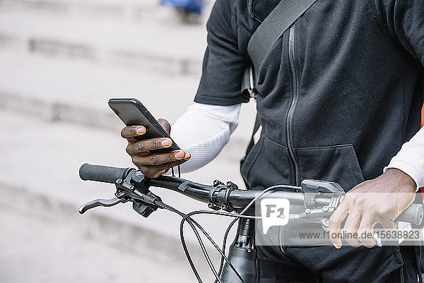 Nahaufnahme eines Mannes mit Fahrrad per Smartphone