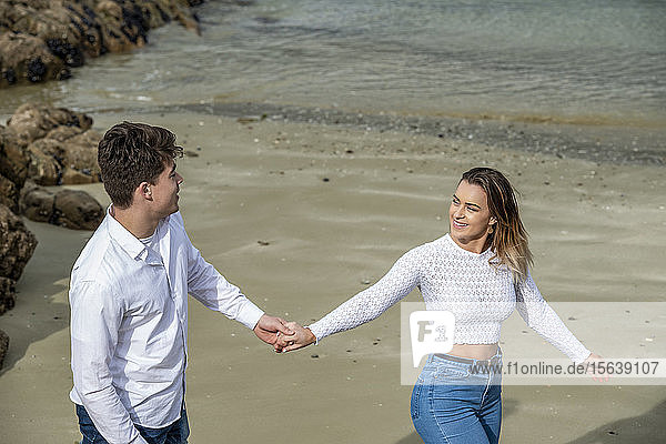 Porträt eines jungen Paares  das seine Zuneigung am Strand zeigt; Wellington  Nordinsel  Neuseeland