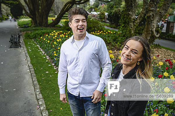 Young man and young woman smiling and laughing in a park; Wellington  North Island  New Zealand
