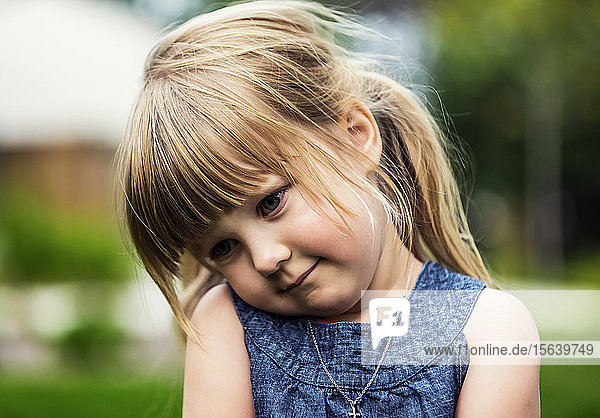 Porträt eines niedlichen jungen Mädchens mit blondem Haar  das schüchtern zu Boden schaut; Edmonton  Alberta  Kanada