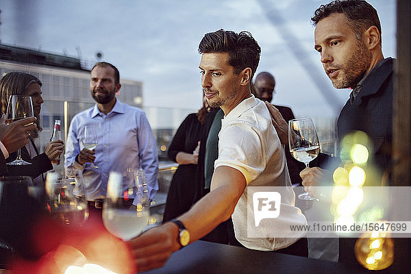 Männliche und weibliche Kollegen trinken Wein und feiern Erfolge auf einer Party nach der Arbeit