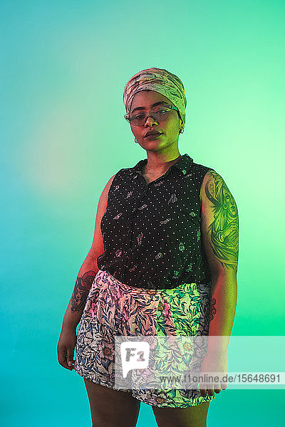 Young woman in turban posing against turquoise background