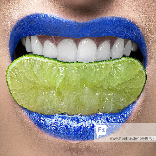 Blaue Lippen beißen auf Limettenscheibe