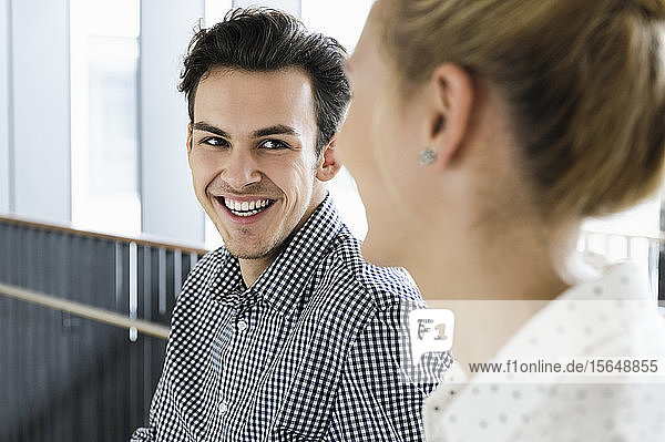 Businessman and businesswoman talking in office