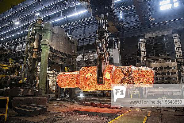 Red hot steel ingot being craned to forge in steelworks