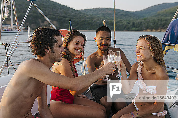 Friends toasting with champagne on sailboat  Italy