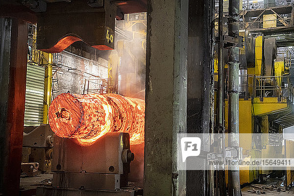 Red hot steel ingot in steel press in steelworks