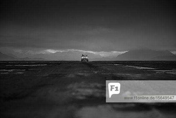 Geländewagen auf Feldweg schwarzer Wolkenhimmel im Hintergrund Landmannalaugar Island