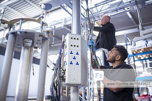 Workers assembling operating theatre lighting in electronics assembly factory