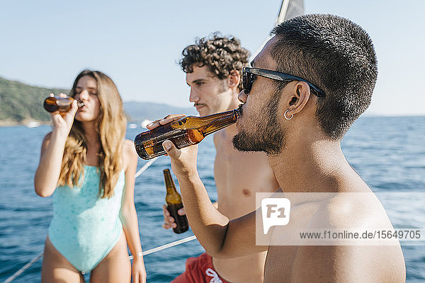 Freunde genießen Bier auf einem Segelboot  Italien