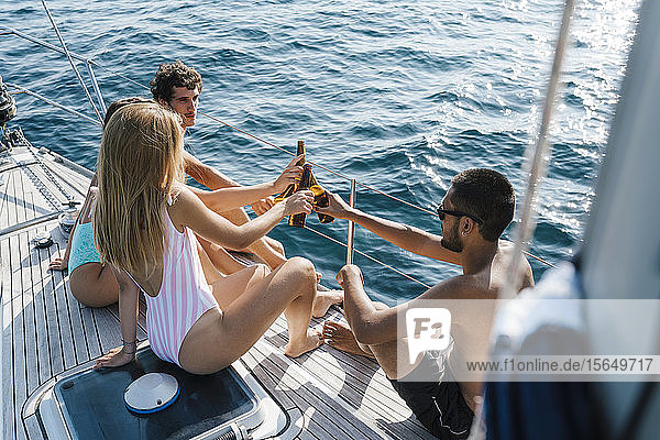 Freunde stoßen mit Bier auf dem Segelboot an  Italien