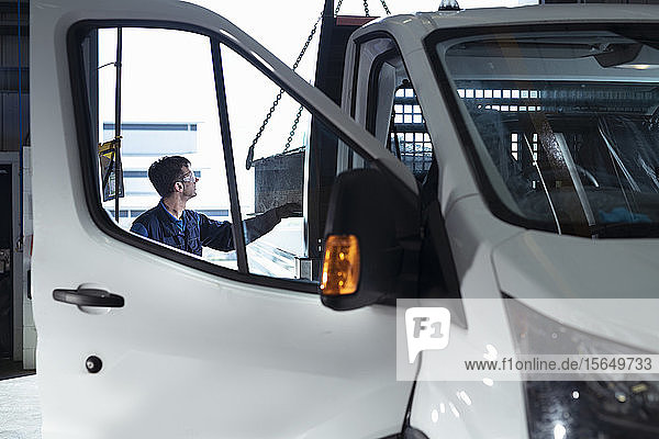 Engineer loading parts into truck in electrical engineering factory