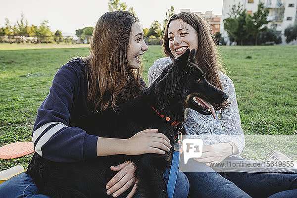 Schwestern mit Hund reden im Park