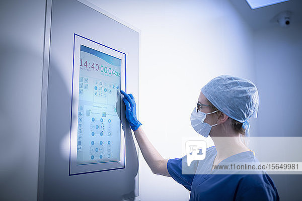 Nurse using operating theatre controls in operating theatre in hospital setting