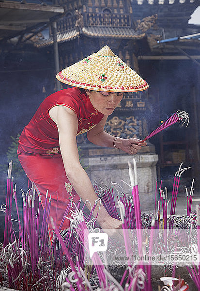 Frau zündet Weihrauch in einem Tempel in Lijang  Shangri-La-Region  Provinz Yunnan  China