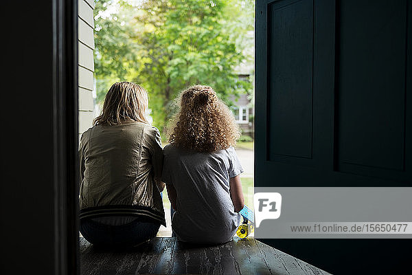 Mother and daughter sitting on porch