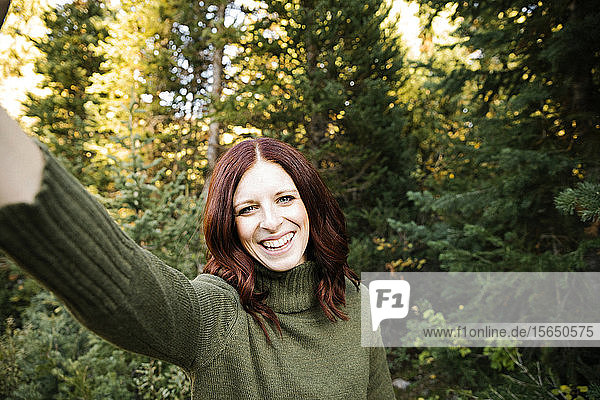 Frau nimmt Selfie im Wald