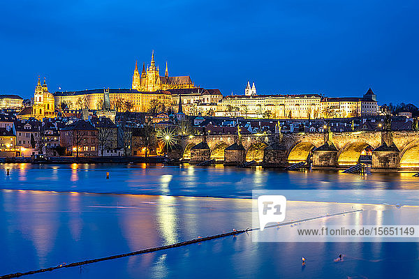 Der Veitsdom und die Prager Burg beleuchtet während der abendlichen blauen Stunde  die sich in der Moldau spiegelt  UNESCO-Weltkulturerbe  Prag  Tschechische Republik