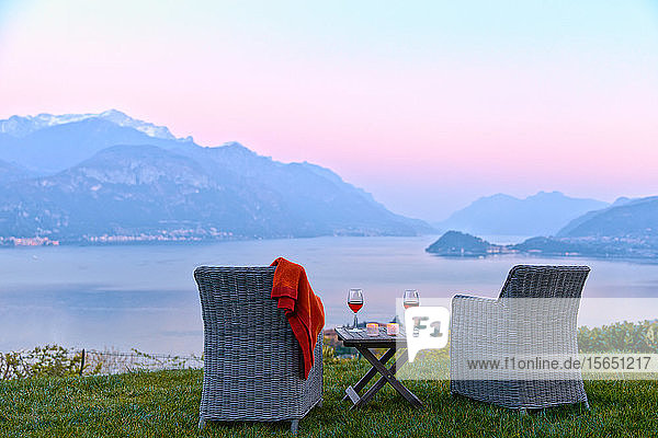 Armchairs and red wine with views of Lake Como at sunset  Lombardy  Italian Lakes  Italy