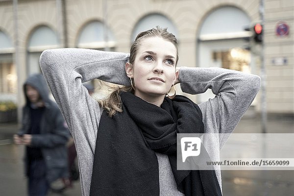 Young woman at street in city  rainy weather. Munich  Germany.